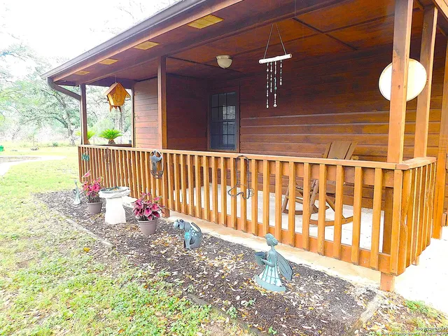 a view of two chairs and table in the patio