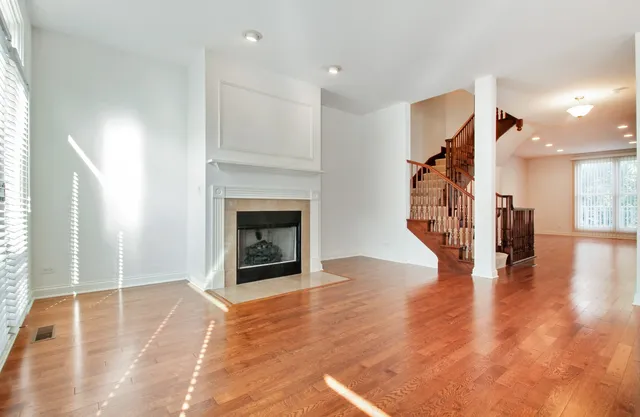a view of a livingroom with wooden floor and a fireplace