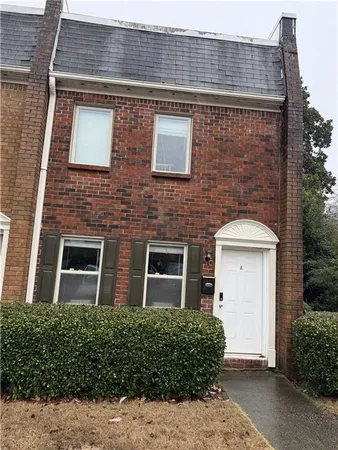 front view of a brick house with a yard