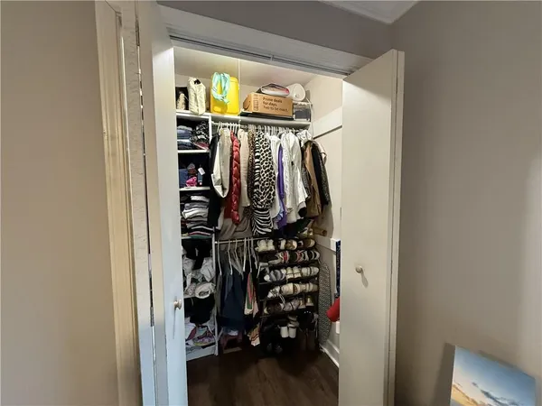 a view of walk in closet with clothes and shoes