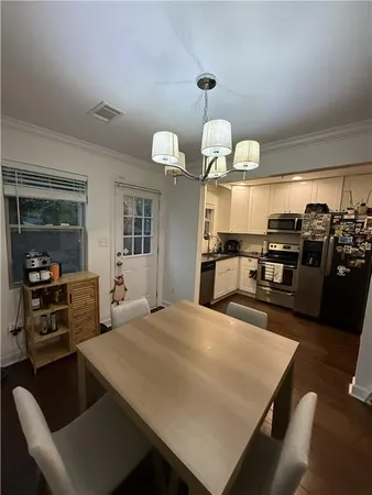 a kitchen with stainless steel appliances kitchen island granite countertop a sink dishwasher a stove and a refrigerator with wooden floor