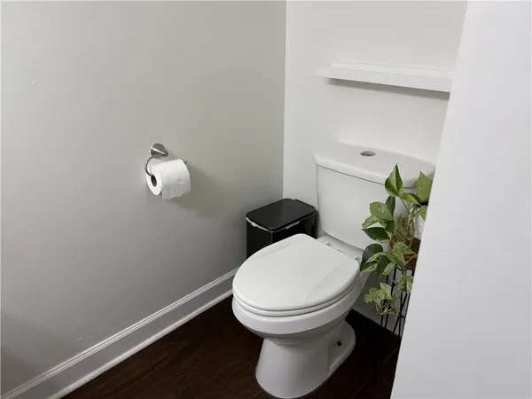 a bathroom with a toilet and a potted plant