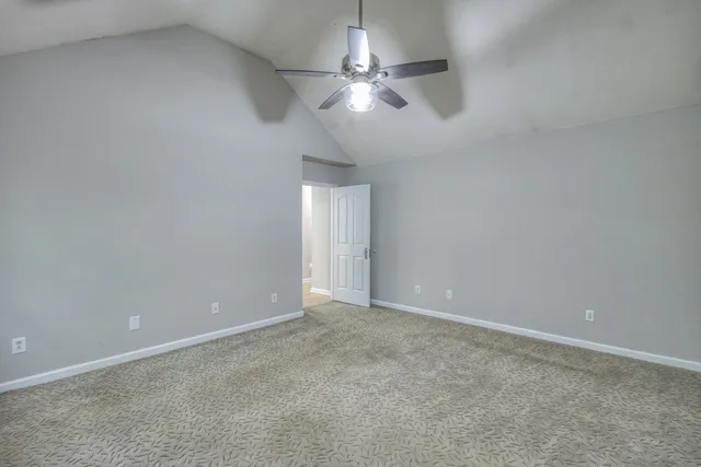 an empty room with a ceiling fan and a window