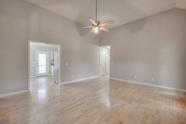 a view of an empty room with window and wooden floor