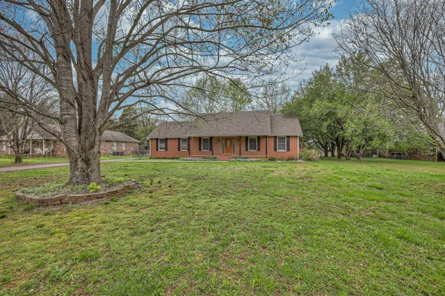 a front view of a house with yard and green space