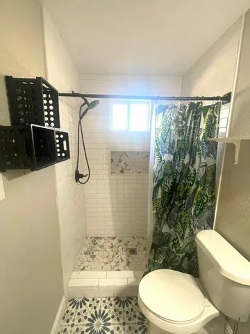 a white toilet sitting next to a bathroom sink and a shower