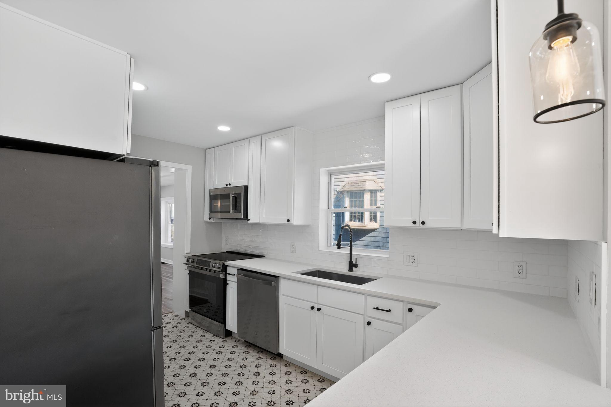 99 Rorer Street Glenside, PA 19038 - Photo 13 of 36 a kitchen with stainless steel appliances a refrigerator sink and white cabinets