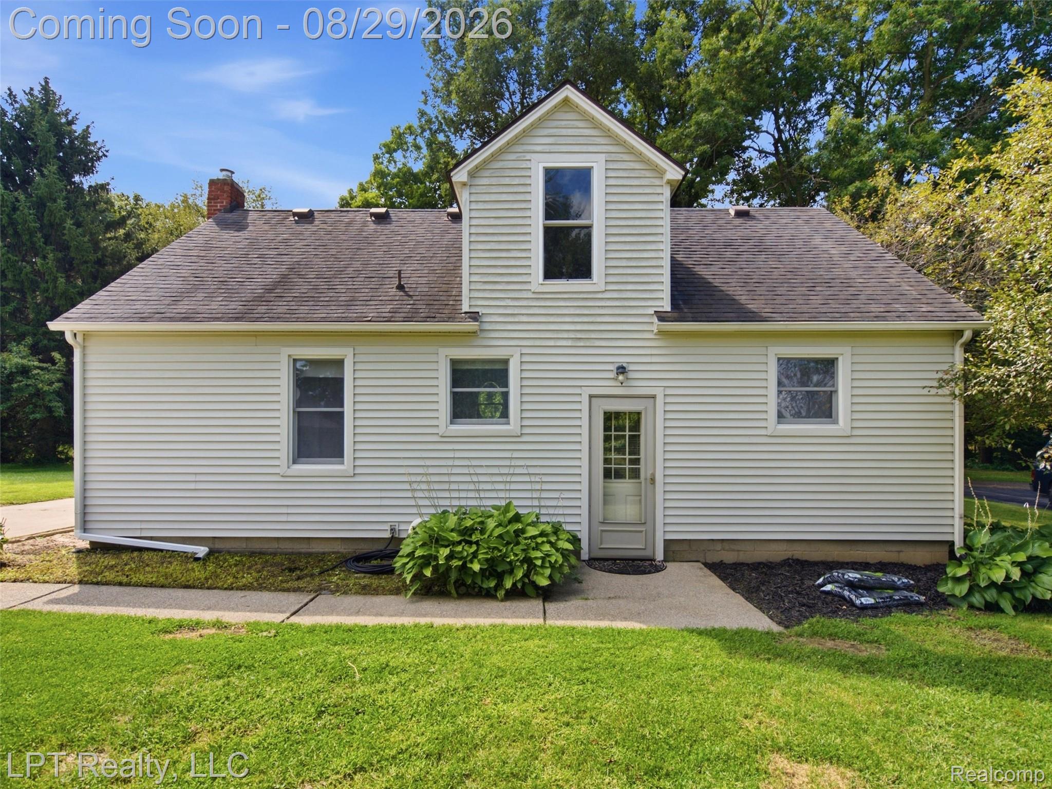 154 Bullis Road Gregory, MI 48137 - Photo 34 of 37 Light-colored horizontal siding, asphalt shingle roofing, and a gabled dormer