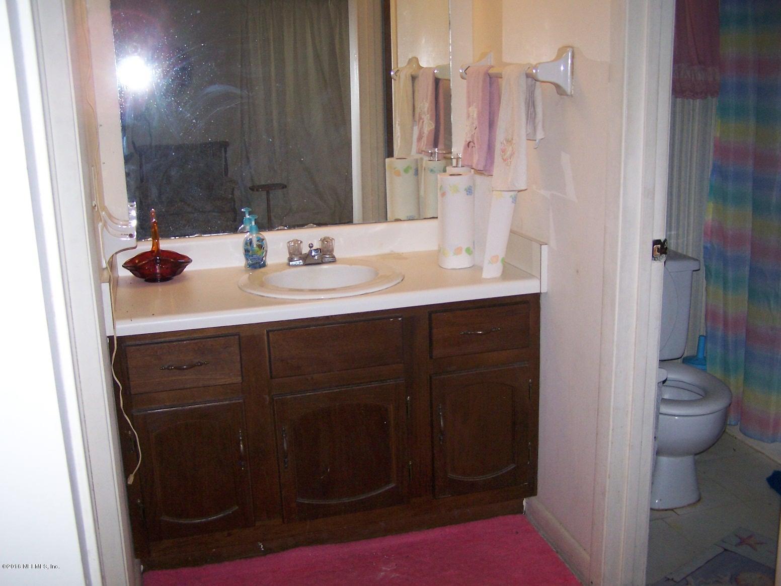4190 Pine Road Orange Park, FL 32065 - Photo 7 of 11 a bathroom with a sink a toilet and a mirror