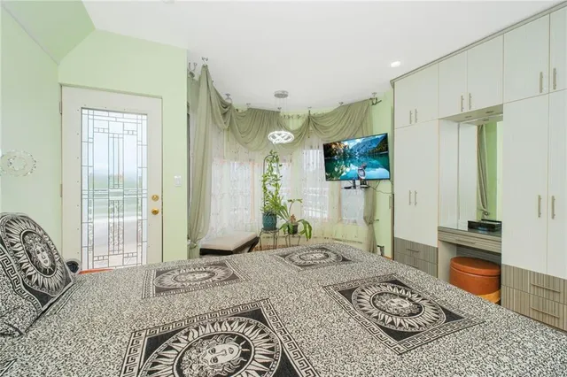 a spacious bedroom with a bed a couch and dresser