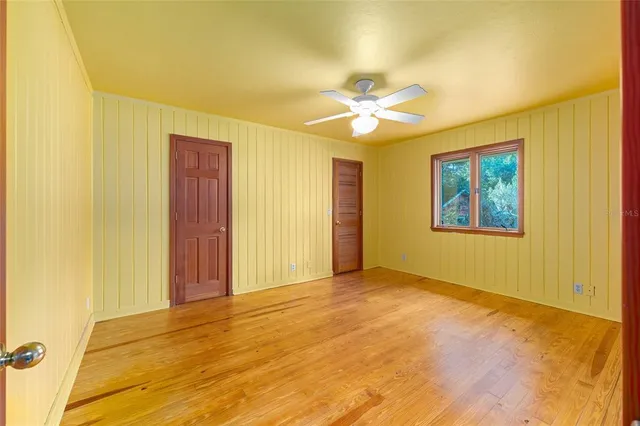 a view of empty room with wooden floor and fireplace