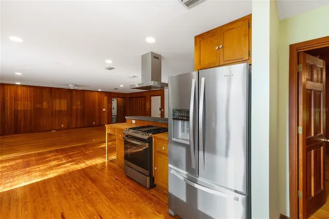 a kitchen with stainless steel appliances granite countertop a refrigerator and a stove