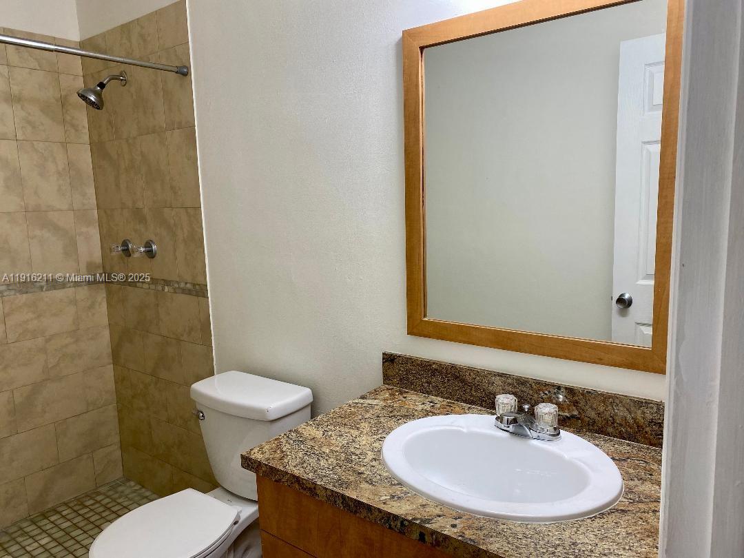 11287 Southwest 88th Street, Unit 209L Miami, FL 33173 - Photo 11 of 16 a bathroom with a sink toilet a mirror and shower