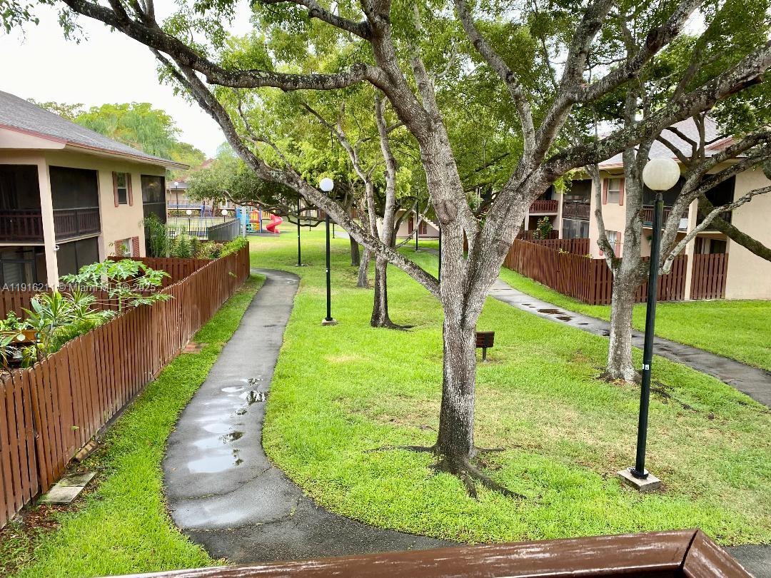 11287 Southwest 88th Street, Unit 209L Miami, FL 33173 - Photo 15 of 16 a front view of a house with a yard table and chairs
