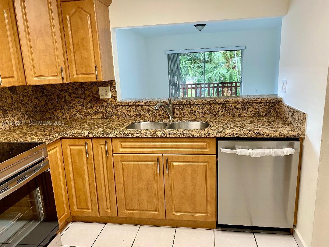 11287 Southwest 88th Street, Unit 209L Miami, FL 33173 - Photo 8 of 16 a kitchen with granite countertop cabinets and window