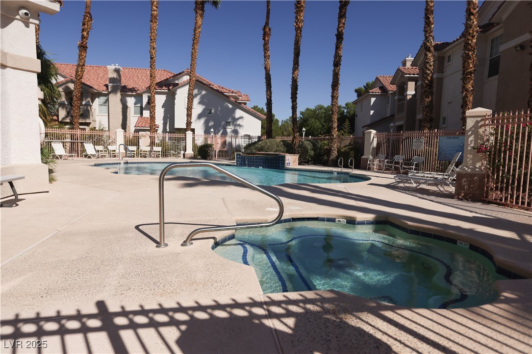 8555 West Russell Road, Unit 1026 Las Vegas, NV 89113 - Photo 18 of 20 Community pool featuring a community hot tub, a patio area, and a residential view