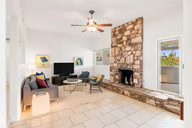 a living room with furniture a fireplace and a flat screen tv