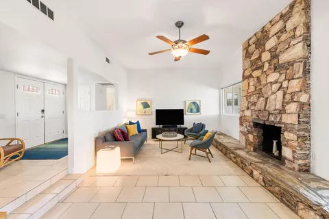 a living room with furniture a fireplace and a flat screen tv