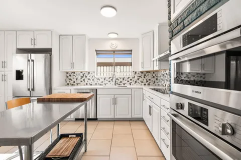 a kitchen with stainless steel appliances granite countertop a sink and cabinets