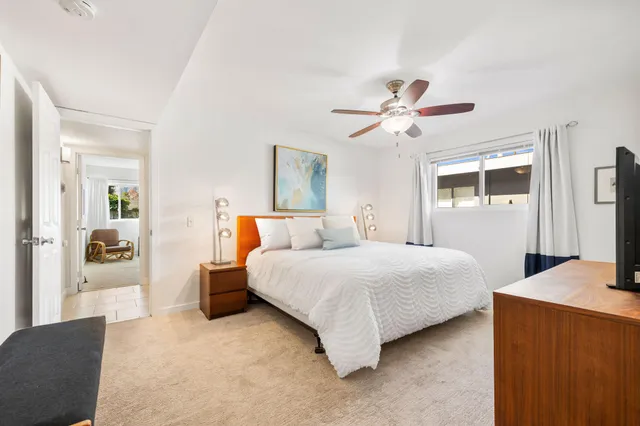 a bedroom with a bed chandelier and a window
