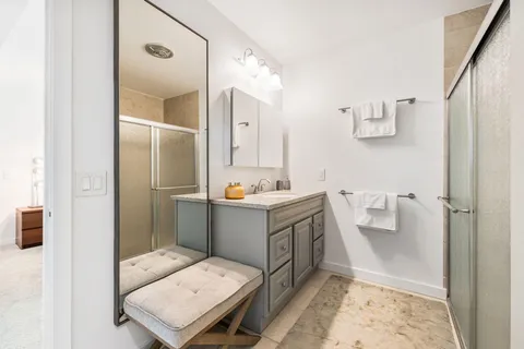a bathroom with a sink mirror and shower