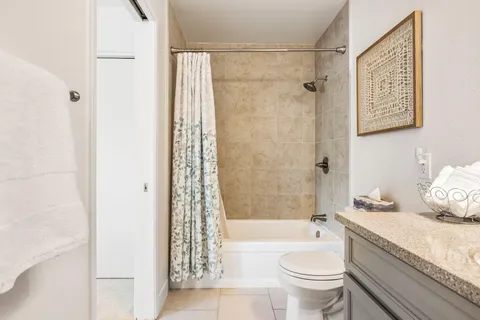 a bathroom with a granite countertop toilet a sink and a bathtub