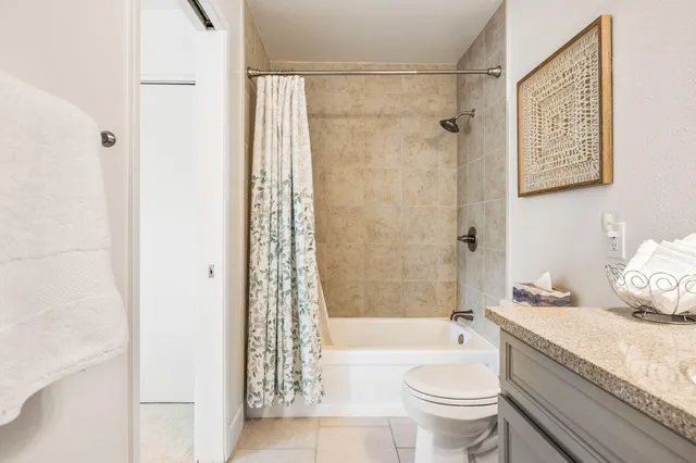 a bathroom with a granite countertop toilet a sink and a bathtub