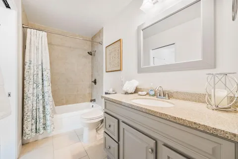 a bathroom with a granite countertop sink a toilet and a bathtub