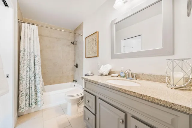 a bathroom with a granite countertop sink a toilet and a bathtub