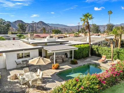 a view of a patio with furniture and a garden