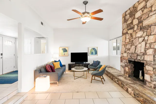 a living room with furniture a fireplace and a flat screen tv
