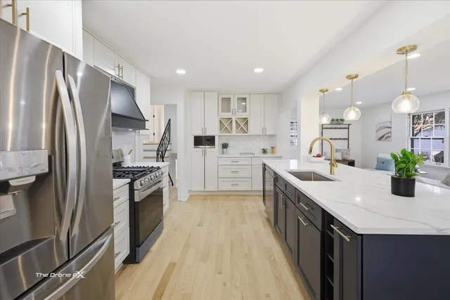 a kitchen with stainless steel appliances a sink stove and refrigerator
