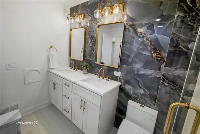 a bathroom with a sink mirror vanity and toilet