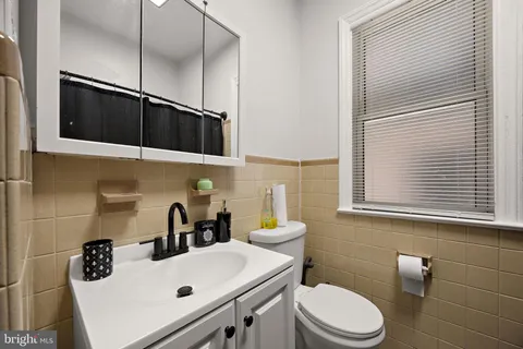 a bathroom with a sink a toilet and mirror