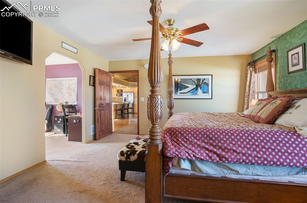 10695 Walker Road Colorado Springs, CO 80908 - Photo 12 of 49 a bedroom with a bed and a chandelier