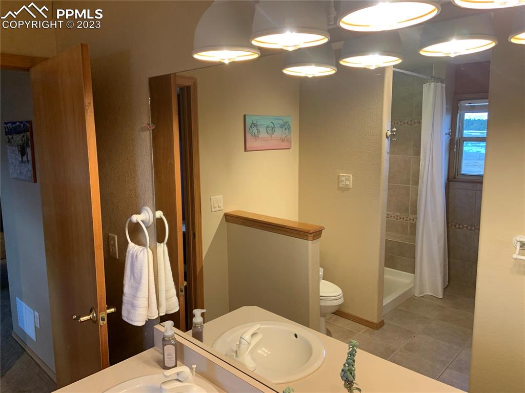10695 Walker Road Colorado Springs, CO 80908 - Photo 15 of 49 a bathroom with a toilet a sink and shower