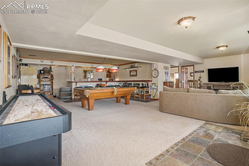 10695 Walker Road Colorado Springs, CO 80908 - Photo 25 of 49 a living room with furniture and flat screen tv