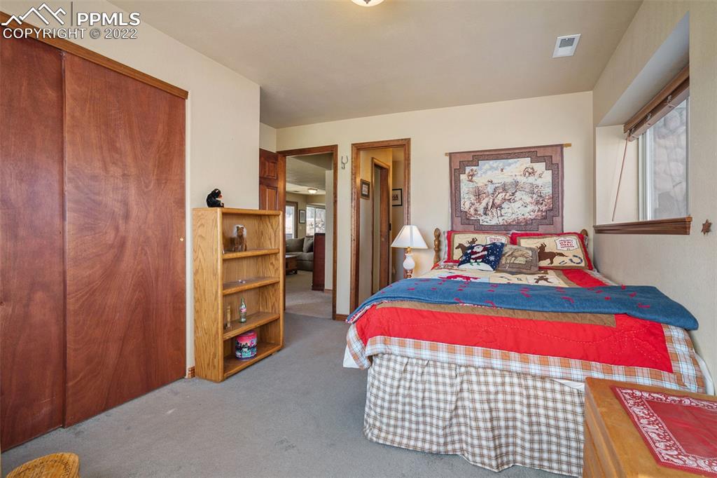 10695 Walker Road Colorado Springs, CO 80908 - Photo 31 of 49 a bedroom with a bed and a window