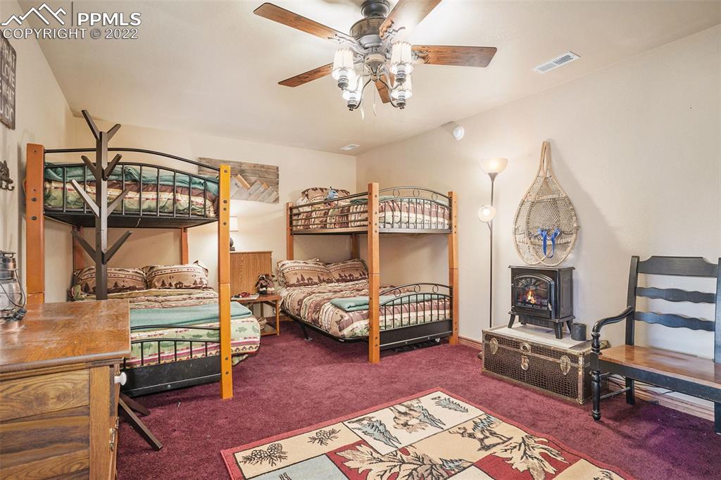 10695 Walker Road Colorado Springs, CO 80908 - Photo 36 of 49 a bedroom with furniture and a chandelier