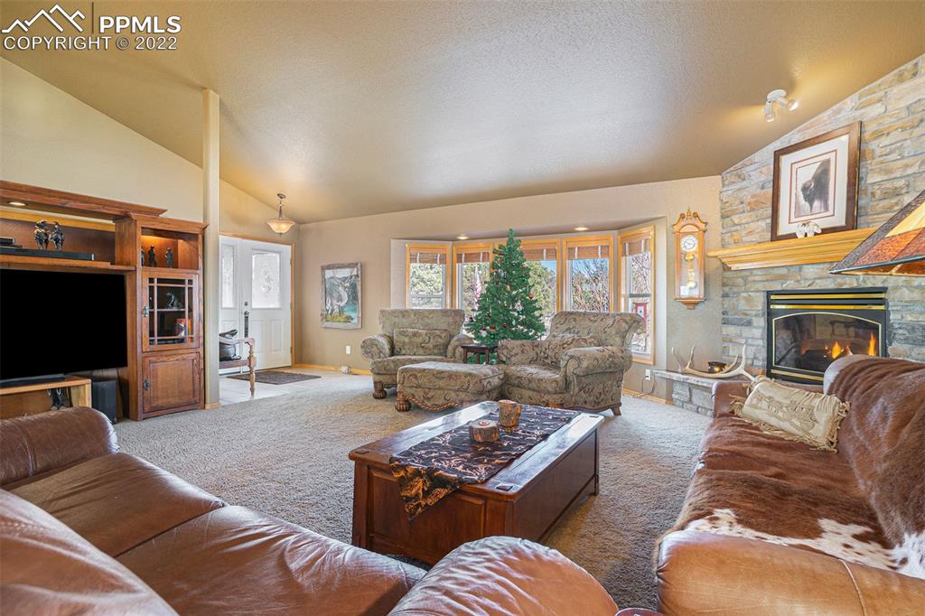10695 Walker Road Colorado Springs, CO 80908 - Photo 9 of 49 a living room with furniture a large window and a flat screen tv