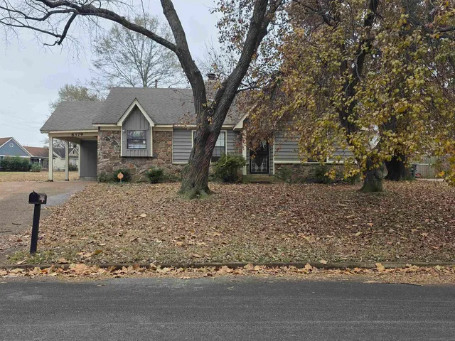 a front view of a house with a yard covered with snow