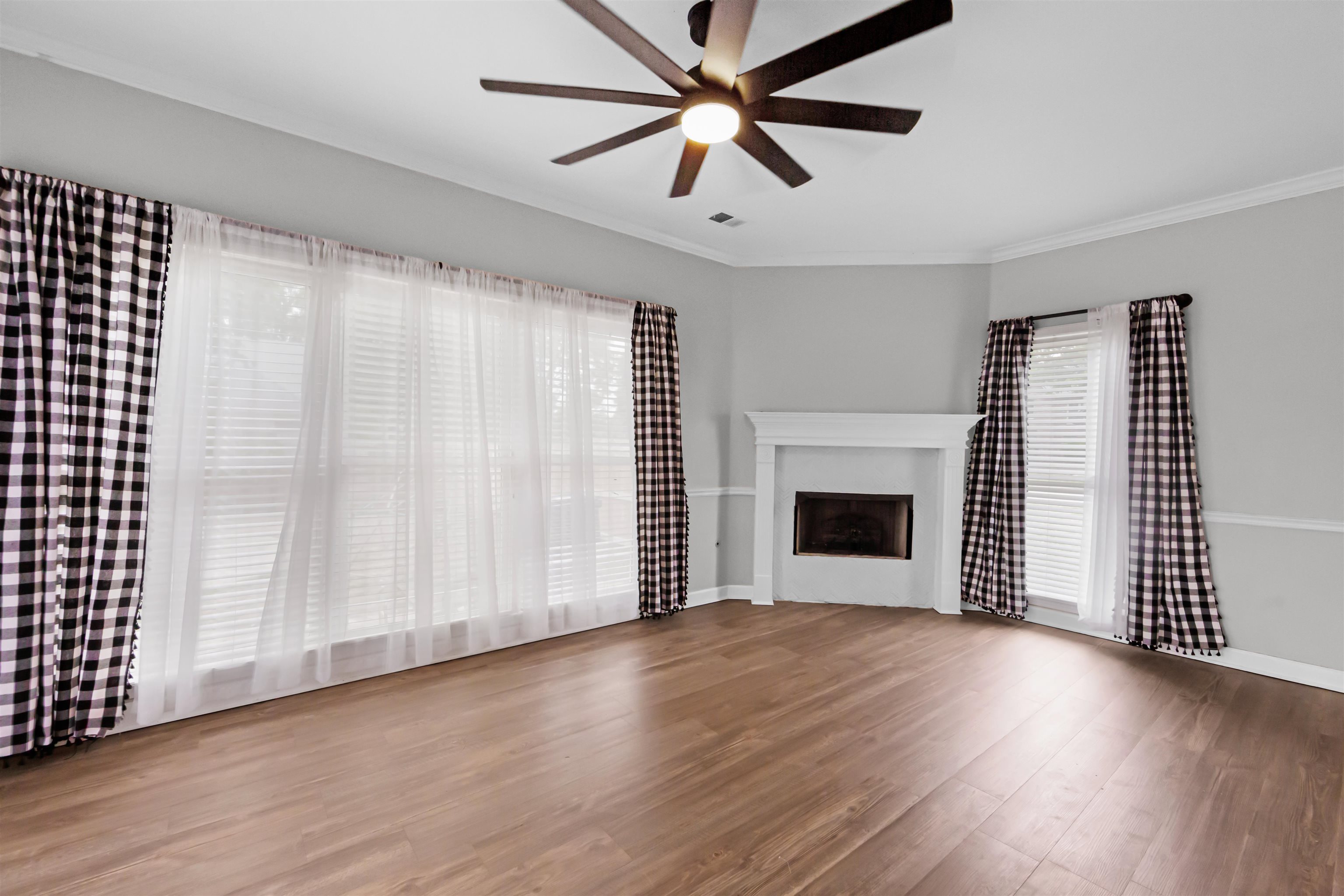 1331 Wahkin Road Collierville, TN 38017 - Photo 6 of 25 an empty room with wooden floor a ceiling fan and windows