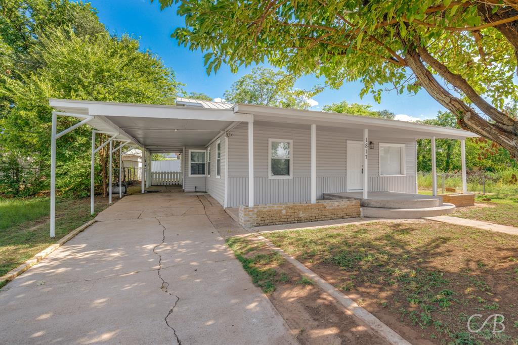 a view of a house with backyard and a tree