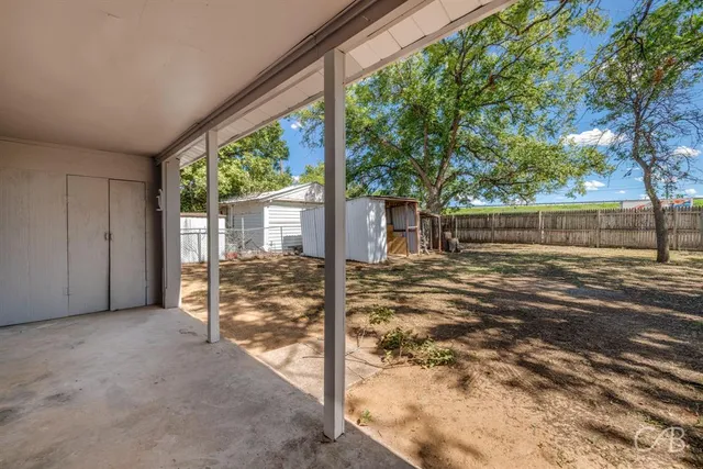 a view of a house with backyard and tree