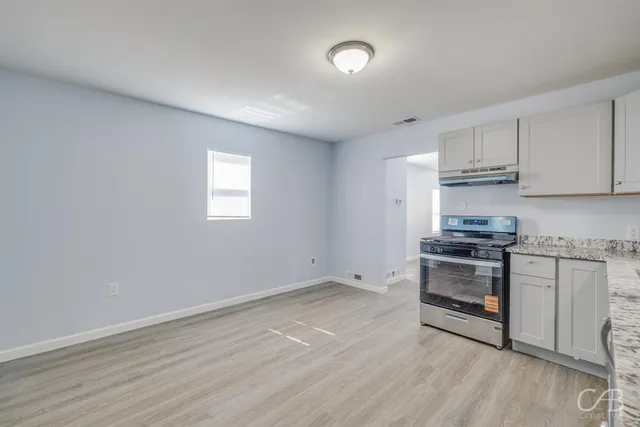 a kitchen with granite countertop a stove and a refrigerator