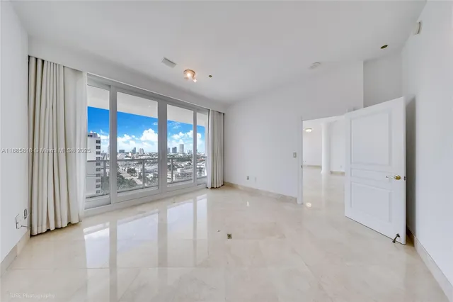 a view of a big room with windows and chandelier fan