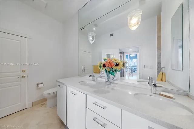 a bathroom with a sink a toilet and mirror