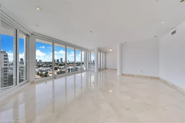 a view of an empty room with a floor to ceiling window and couch