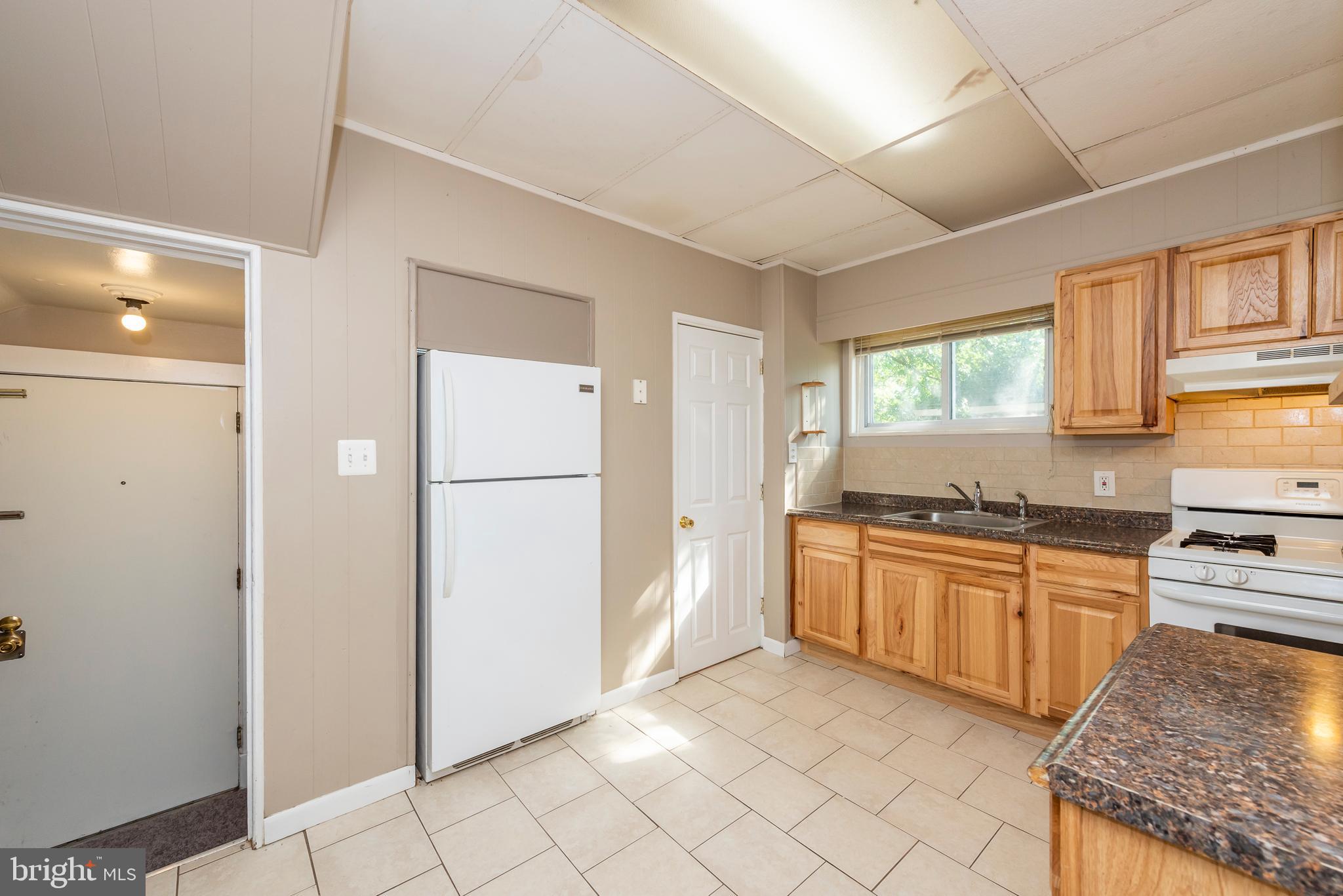 811 Dorchester Road Baltimore, MD 21229 - Photo 11 of 45 a kitchen with stainless steel appliances granite countertop a refrigerator sink and cabinets