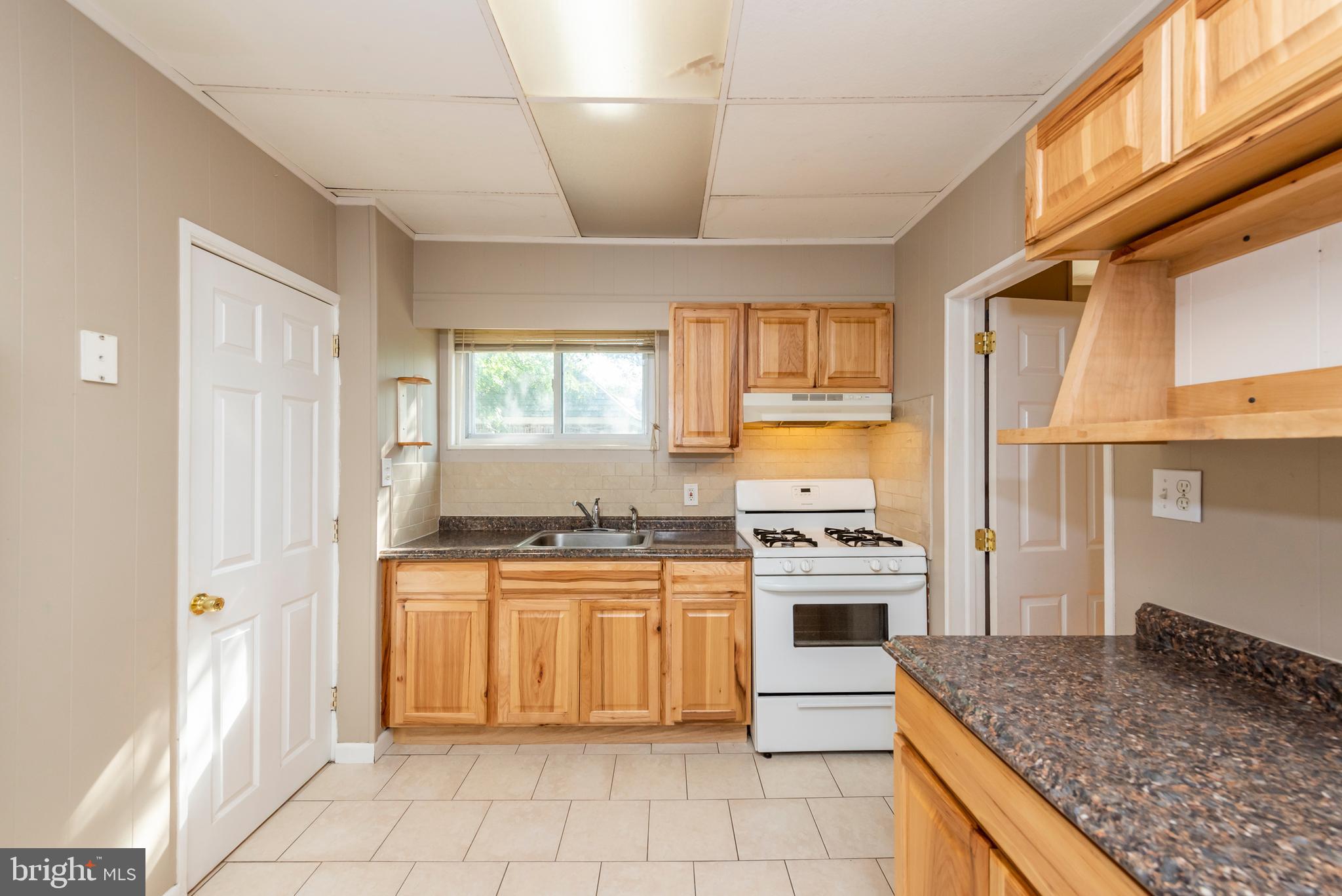 811 Dorchester Road Baltimore, MD 21229 - Photo 13 of 45 a kitchen with stainless steel appliances granite countertop a stove a sink and a refrigerator